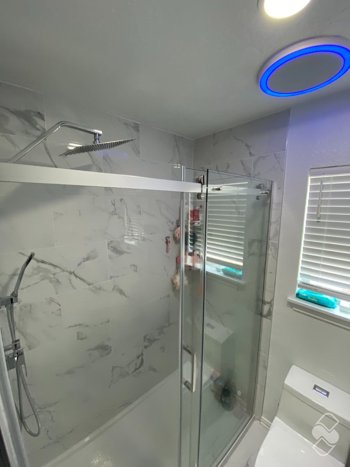 Finished walk in tile shower with rain head, niche and frameless glass