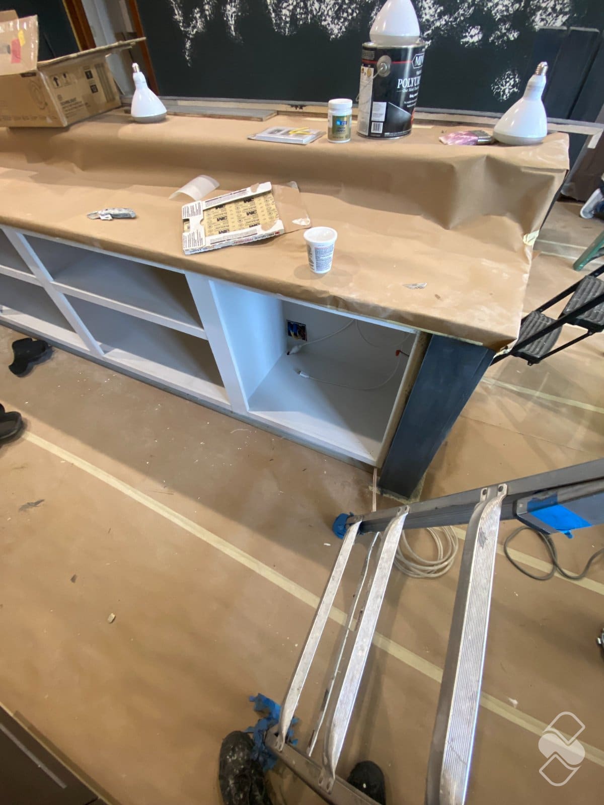 Quartz counters fully covered in protective masking while cabinet interiors are painted