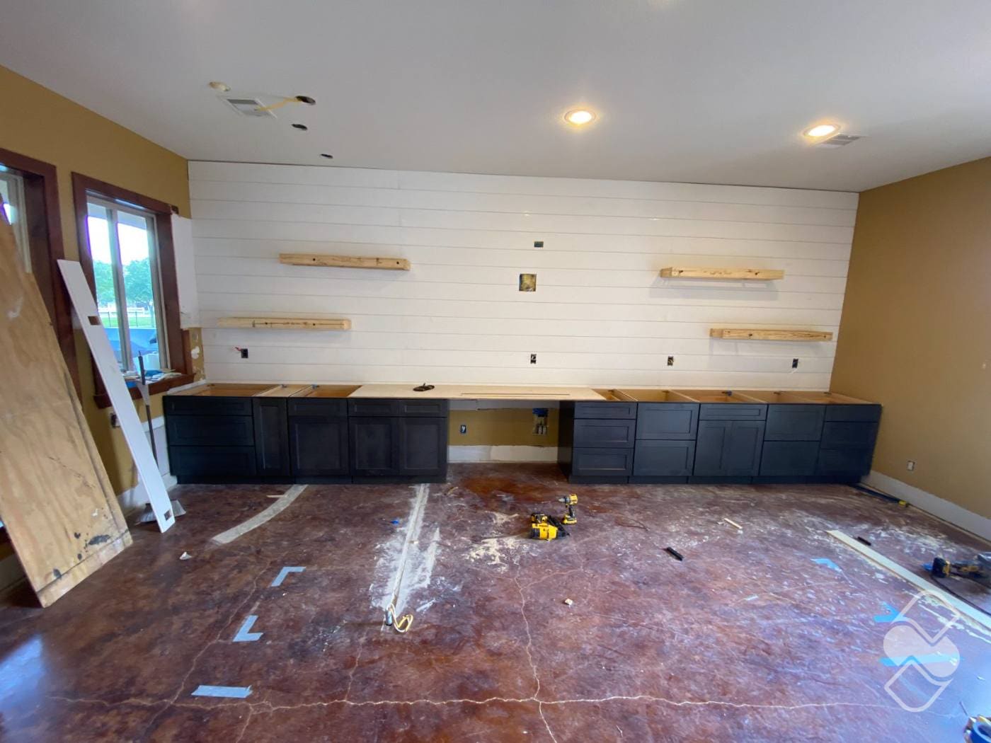 Dark shaker cabinets installed and leveled mid build with the countertop not yet in place