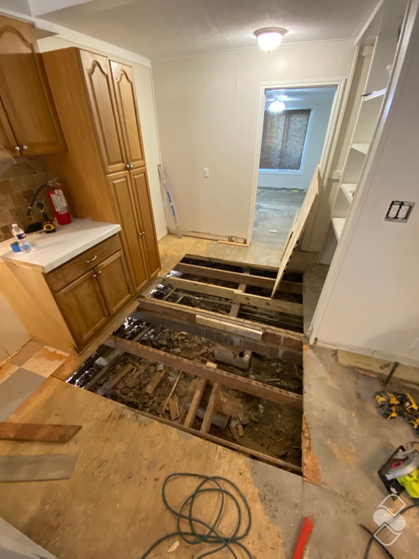Humped wood subfloor cut back to the exposed floor joists during repair