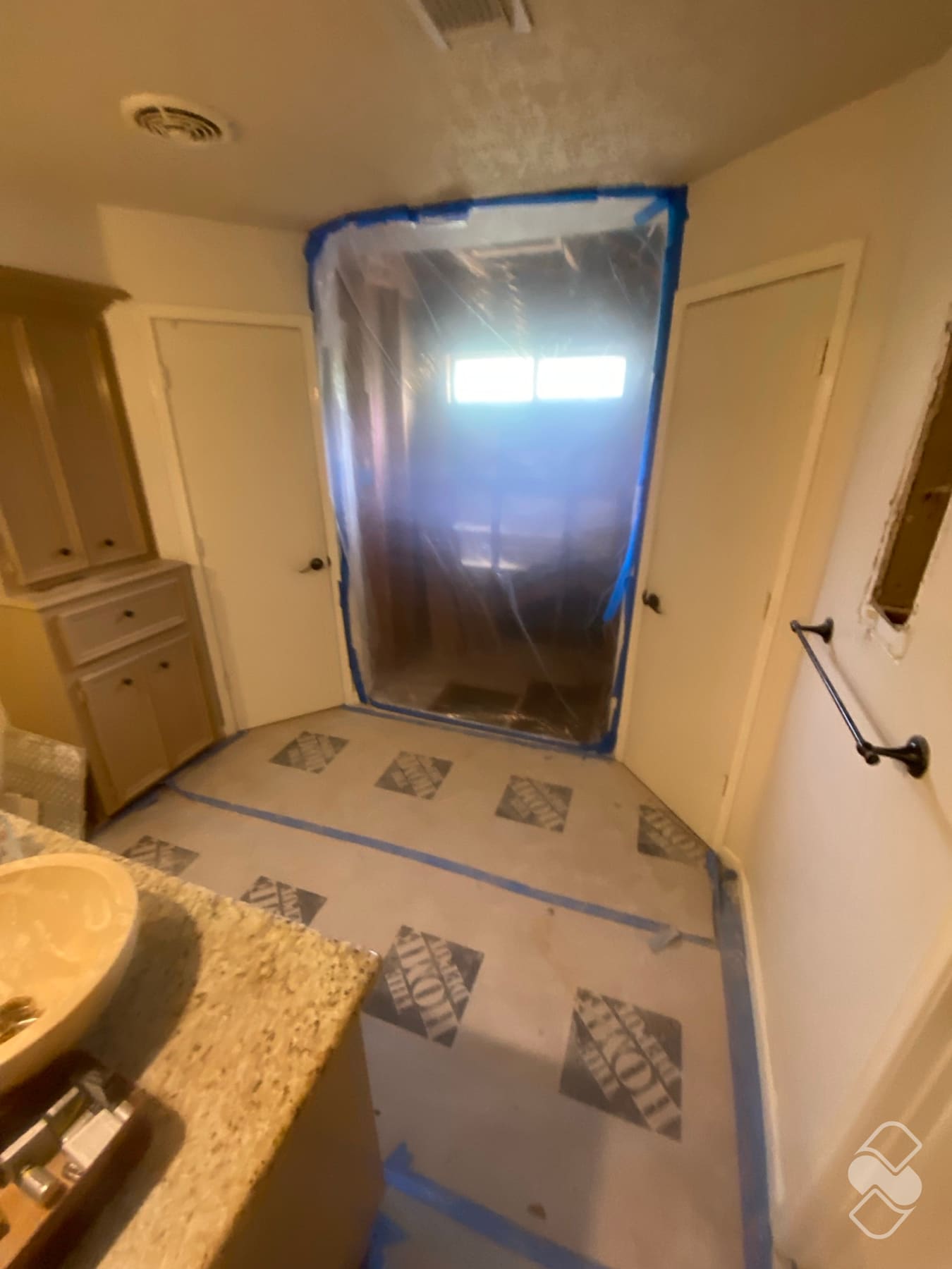 Bathroom floor and fixtures covered with protective sheeting during remodeling work